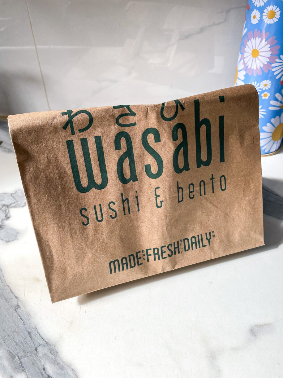 Brown paper shopping bag with Wasabi logo, to ripen peaches on the countertop