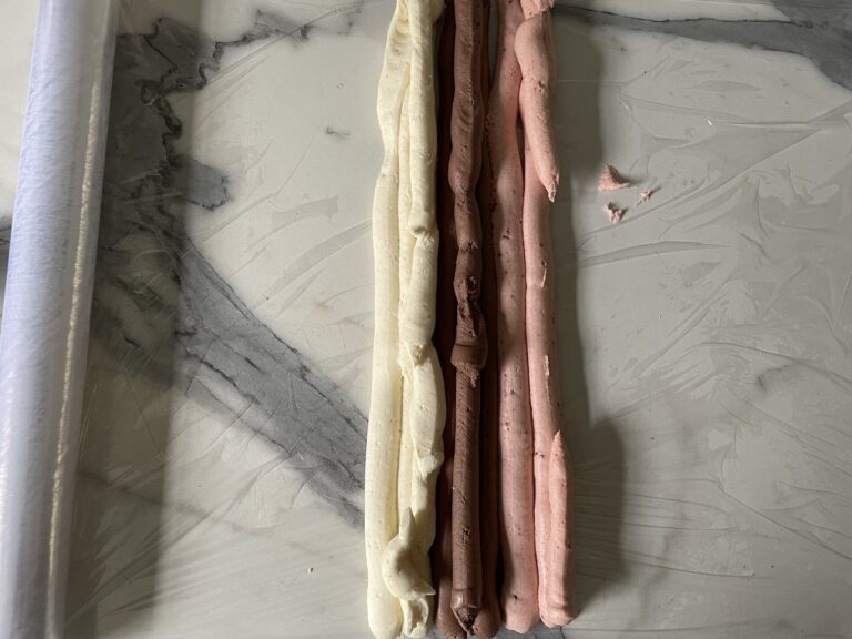 Piped rows of vanilla, chocolate, and strawberry buttercream