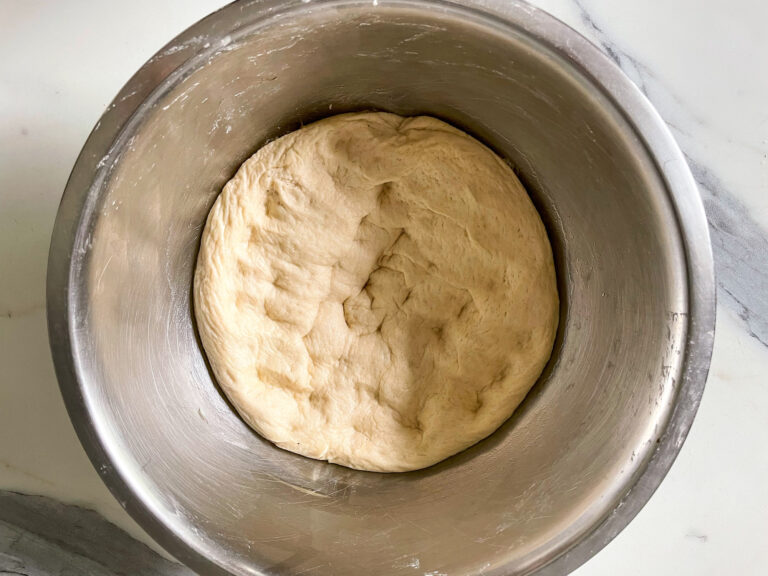 Punched-down pizza dough in bowl