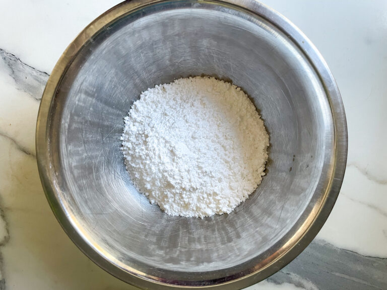 A metal bowl filled with confectioner's sugar