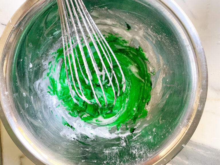 Whisk in a metal bowl with green glaze