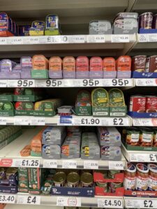 Rows of tinned fish on the shelves of a London grocery store