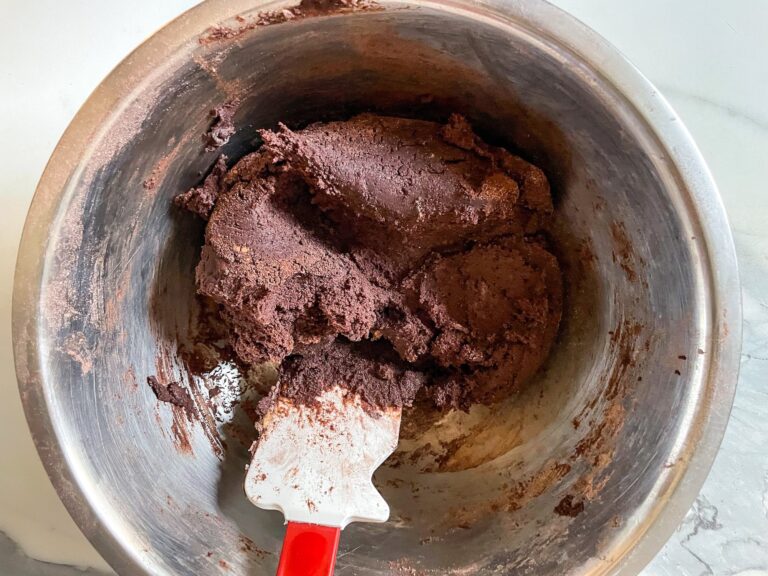 Chocolate cookie dough in metal bowl with rubber spatula