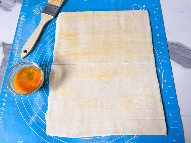 Egg washed puff pastry on a silicone mat