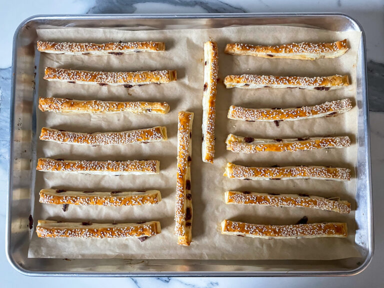 Golden brown anchovy sticks on a parcment lined tray