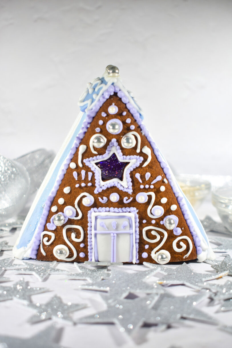 Purple and white piped gingerbread house