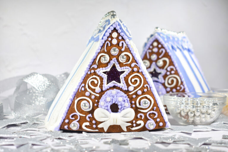 Two purple and white decorated gingerbread houses