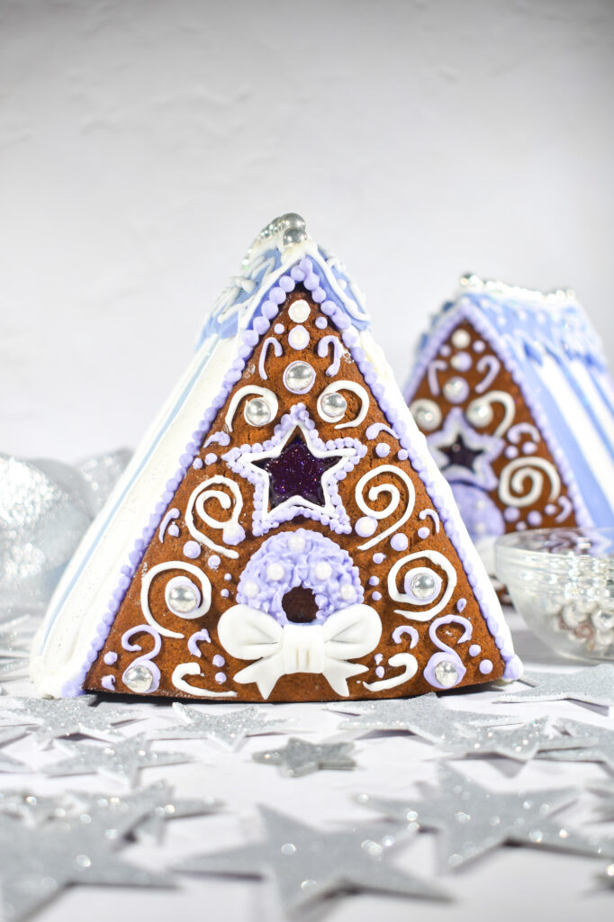 Gingerbread houses and silver stars on white background