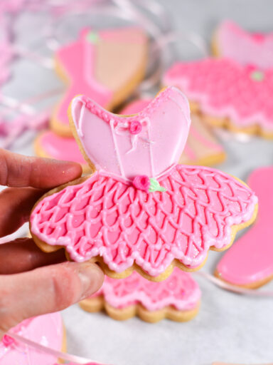 Hand holding ballerina royal icing cookie