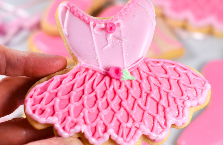 Hand holding ballerina royal icing cookie