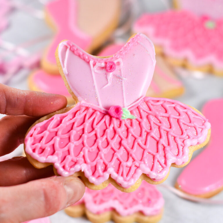 Hand holding ballerina royal icing cookie