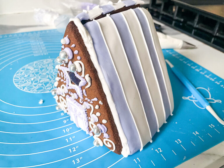 Gingerbread house being constructed on a silicone baking mat