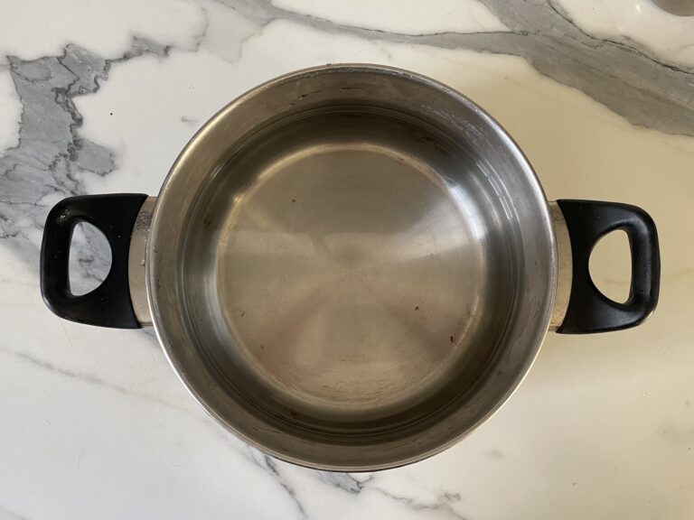 Metal saucepan on marble countertop
