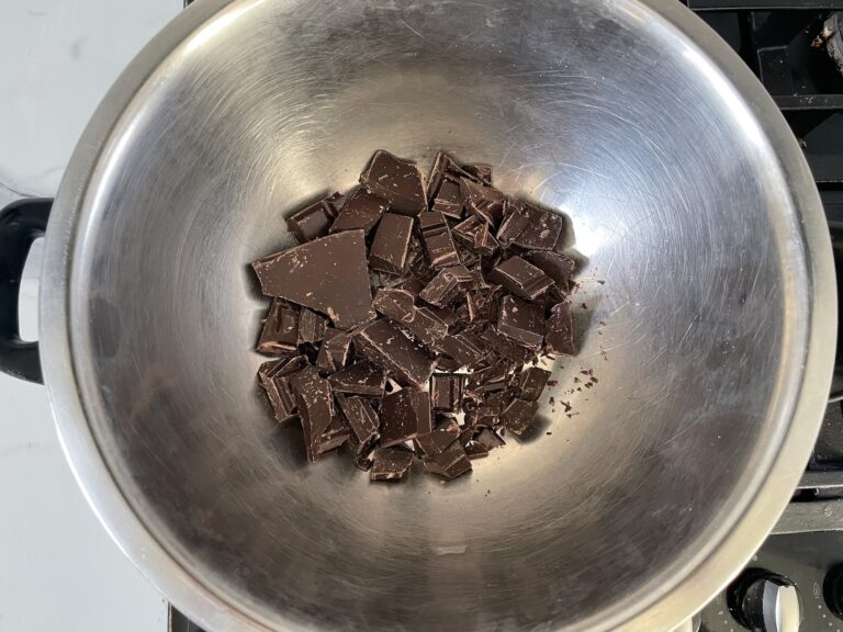 Bain marie consisting of metal bowl with chopped chocolate