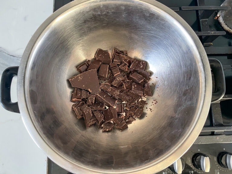 Chopped chocolate in metal bowl over bain marie