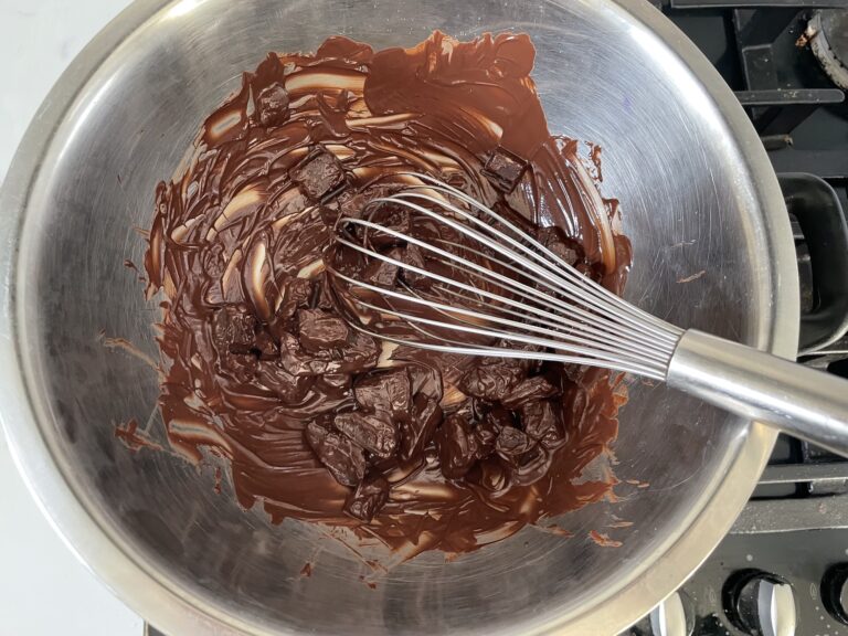 Melted chocolate and whisk in metal bowl