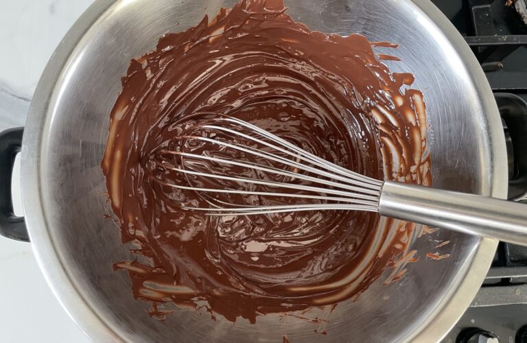 Melted chocolate and whisk in metal bowl