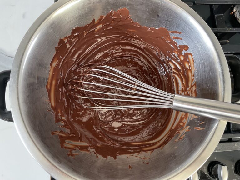 Melted chocolate and whisk in metal bowl