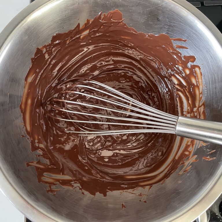 Melted chocolate and whisk in metal bowl