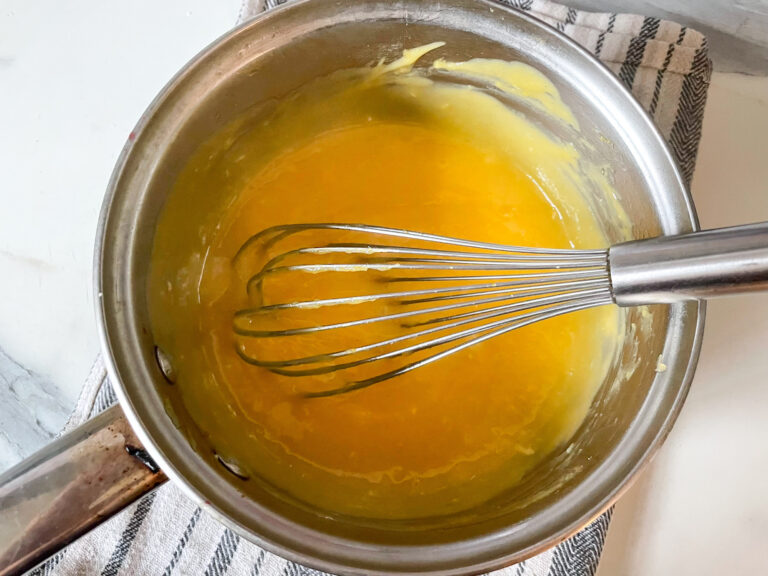 Lemon curd in a saucepan with a whisk