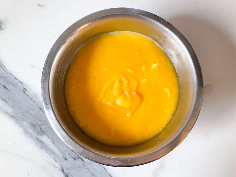 A bowl of lemon curd on a marble countertop