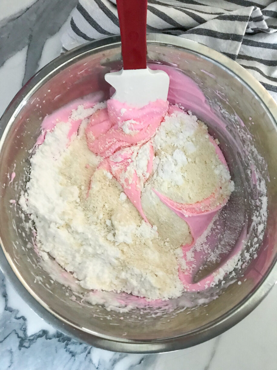Almond flour and meringue in bowl with spatula