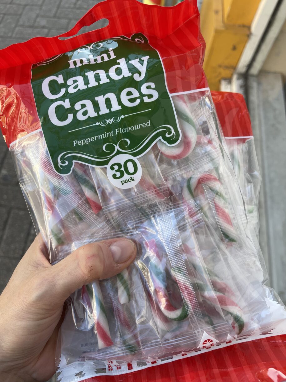 Hand holding a bag of miniature candy canes