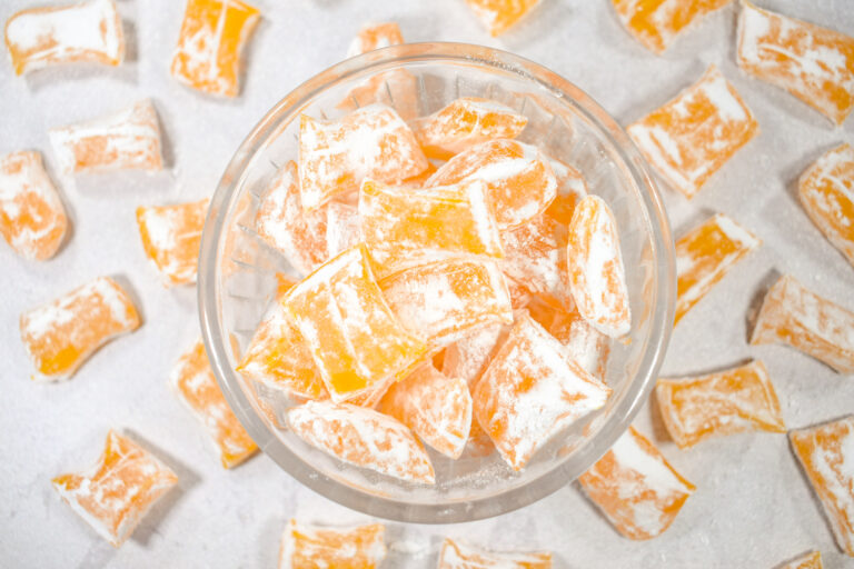 A bowl of homemade lemon drops candy on a white surface