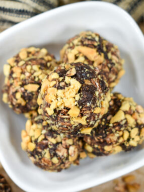 Oatmeal bites in a dish, with peanuts and a striped tea towel