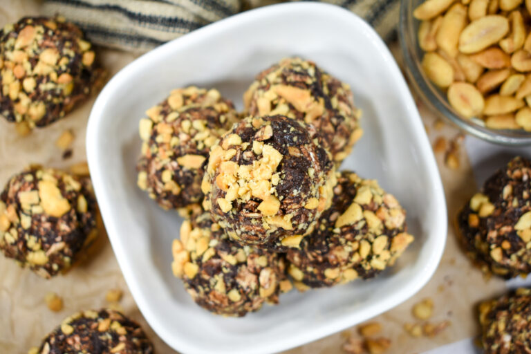 Oatmeal bites in a dish, with peanuts and a striped tea towel