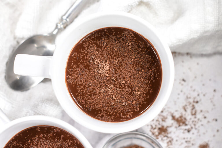 Looking down into a mug of hot chocolate topped with chocolate shavings