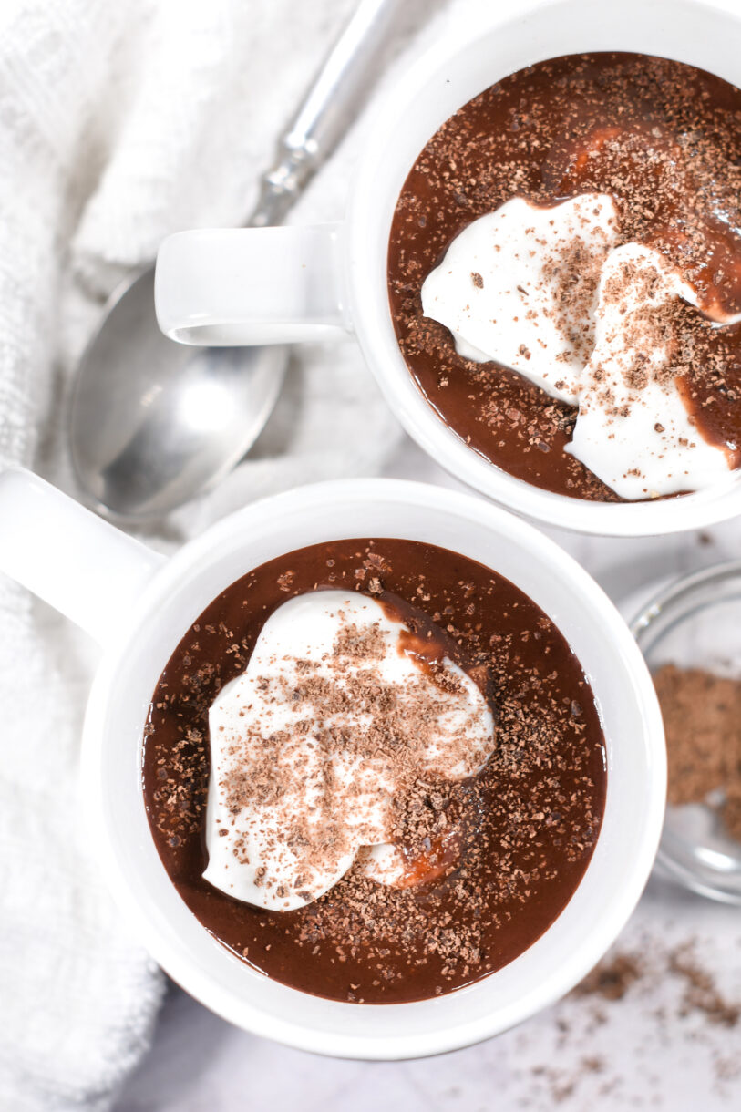Looking down into mugs of cocoa topped with whipped cream