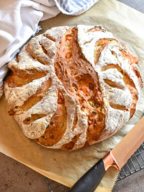 A loaf of bread, knife, and tea towel