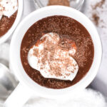 Looking down into a mug of hot chocolate topped with whipped cream