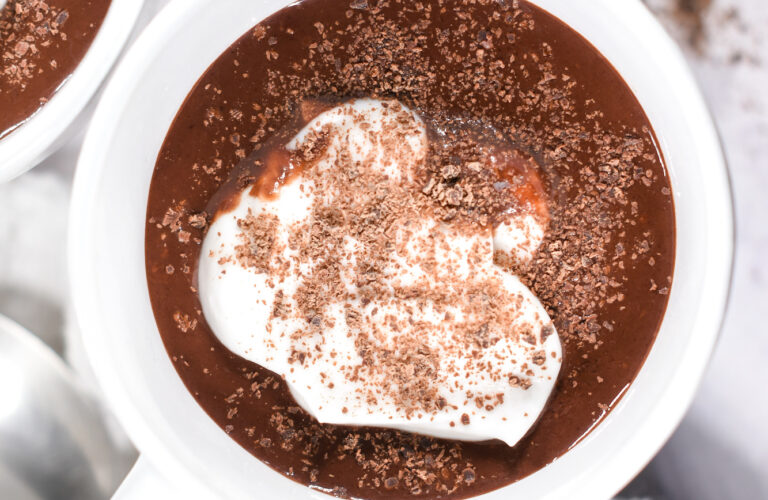 Looking down into a mug of hot chocolate topped with whipped cream