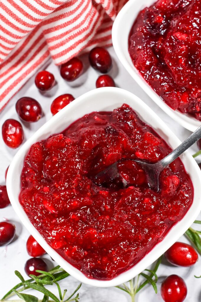 Bowl of cranberry compote and fresh cranberries