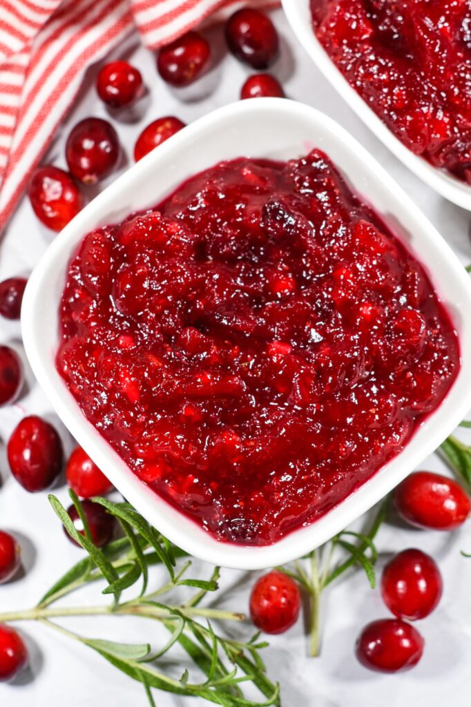 Bowl of cranberry compote and fresh cranberries