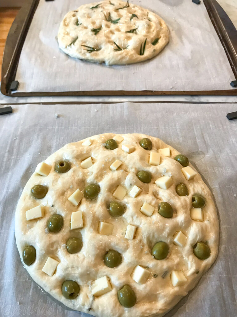 Two loaves of unbaked focaccia bread