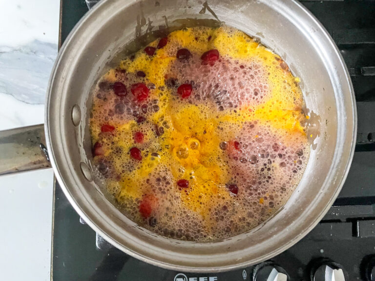 Cranberries and oranges boiling on stovetop