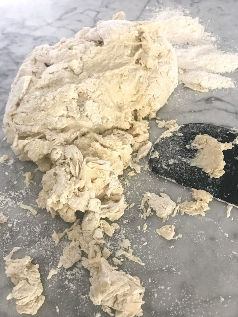 Bread dough and scraper on a rolling mat