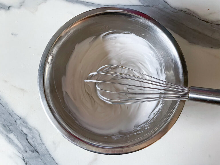 A bowl of coconut cream and a whisk