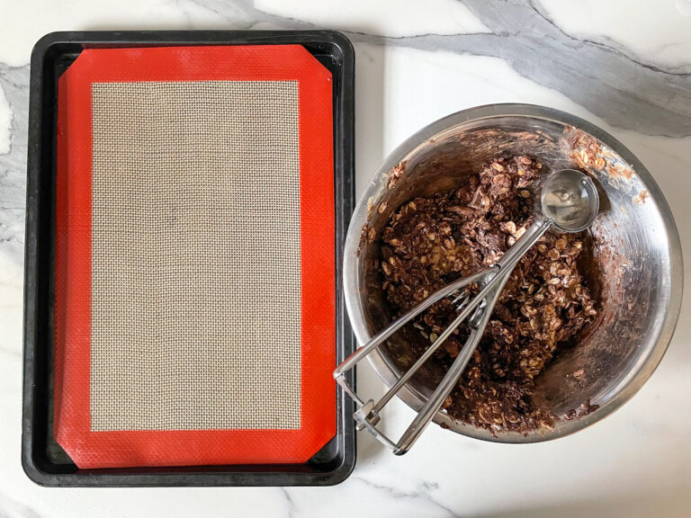 A tray with a silicone mat and a bowl of oatmeal ball dough