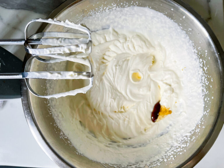 Hand mixer and whipped cream in a bowl