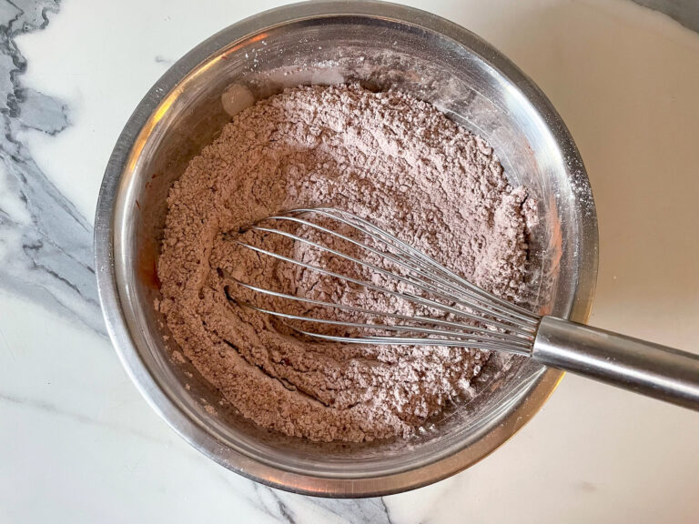 A bowl of cocoa powder and a whisk