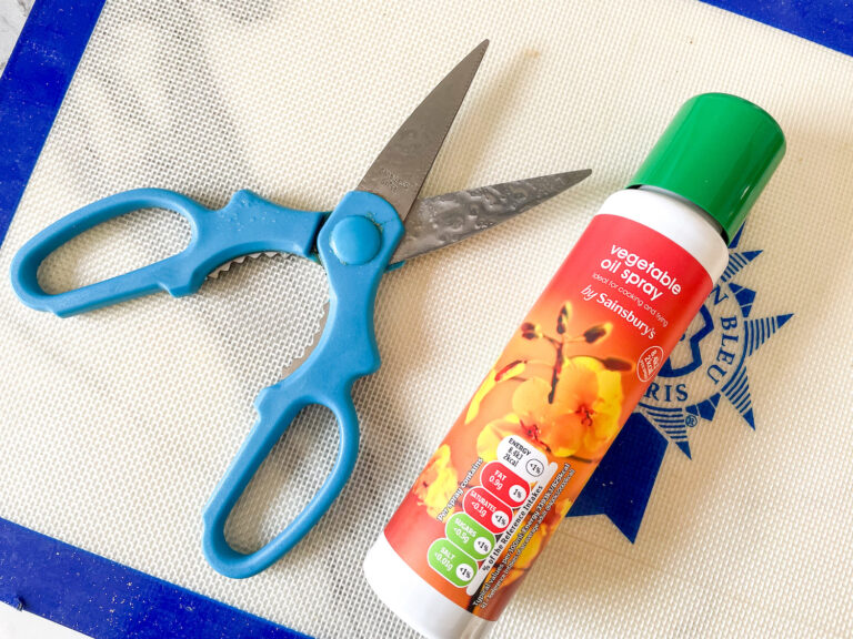 A silicone mat with scissors and vegetable oil spray