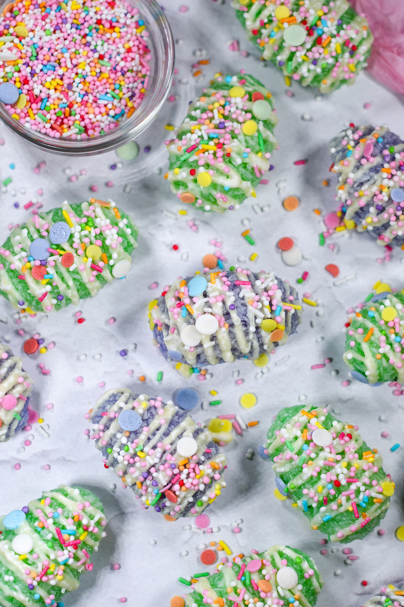 pastel colored coconut Easter eggs on a white surface with sprinkles