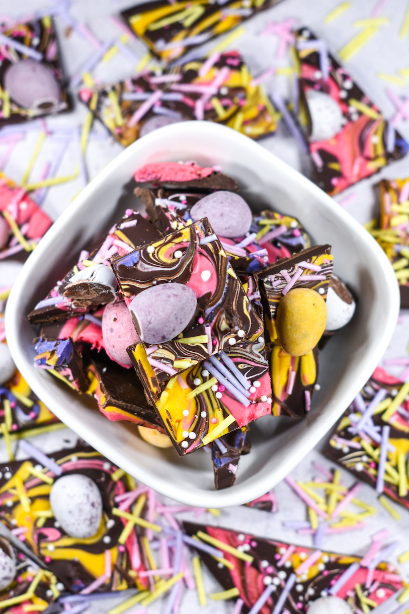 a bowl of chocolate mini egg bark on a white surface