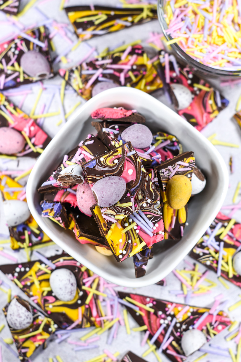 Bowl of mini egg chocolate bark on a white surface