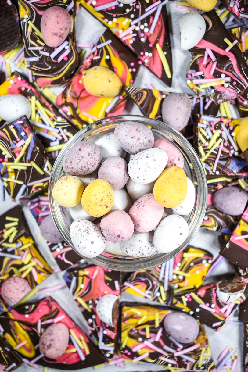 A bowl of mini eggs surrounded by chocolate Easter bark