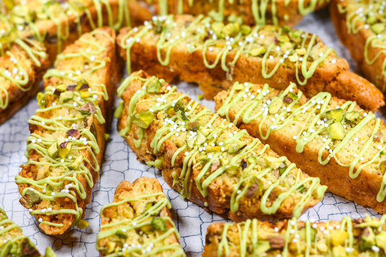 Pistachio white chocolate biscotti on a textured surface